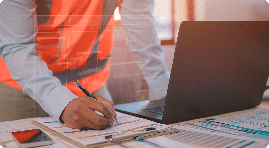 Person in safety vest at desk workstation
